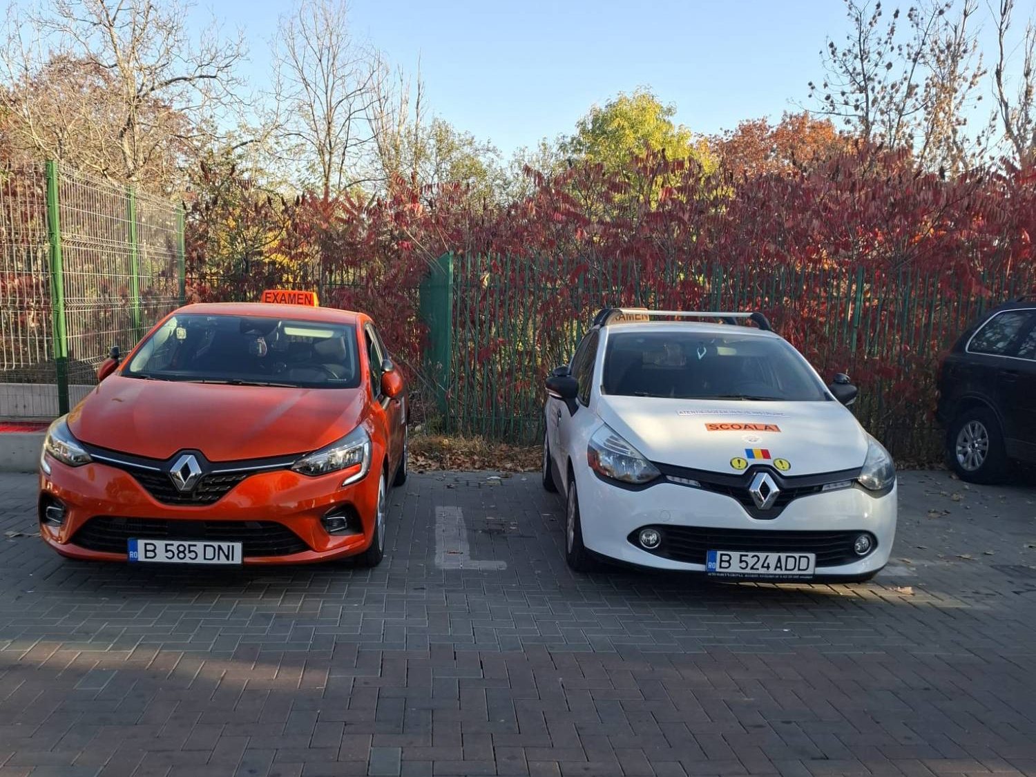 Două Renault Clio ale școlii Auto Dany Drive, cu semnele „Examen” și „Școală”
